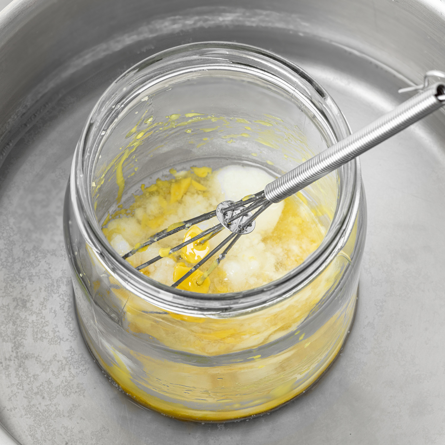 Shaebutter, Wollfett und Aprikosenkernöl grob gemischt im Wasserbad mit kleinem Schneebesen